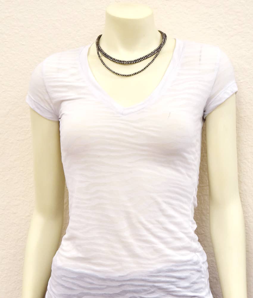 Handmade Navajo bead necklace layered over a white V-neck t-shirt on a mannequin
