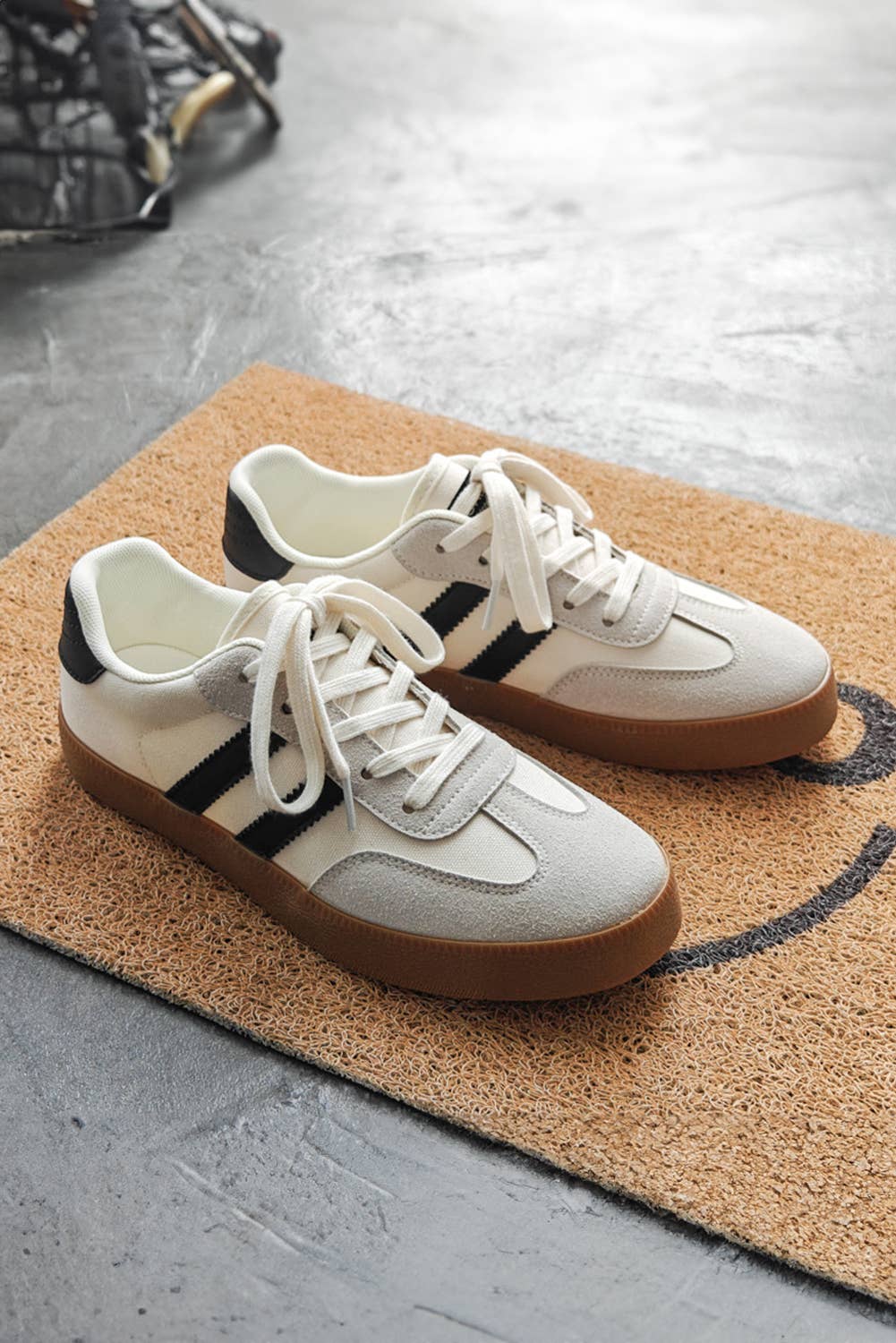 Aapparella striped lace-up sneakers in white with black stripes and a brown rubber sole