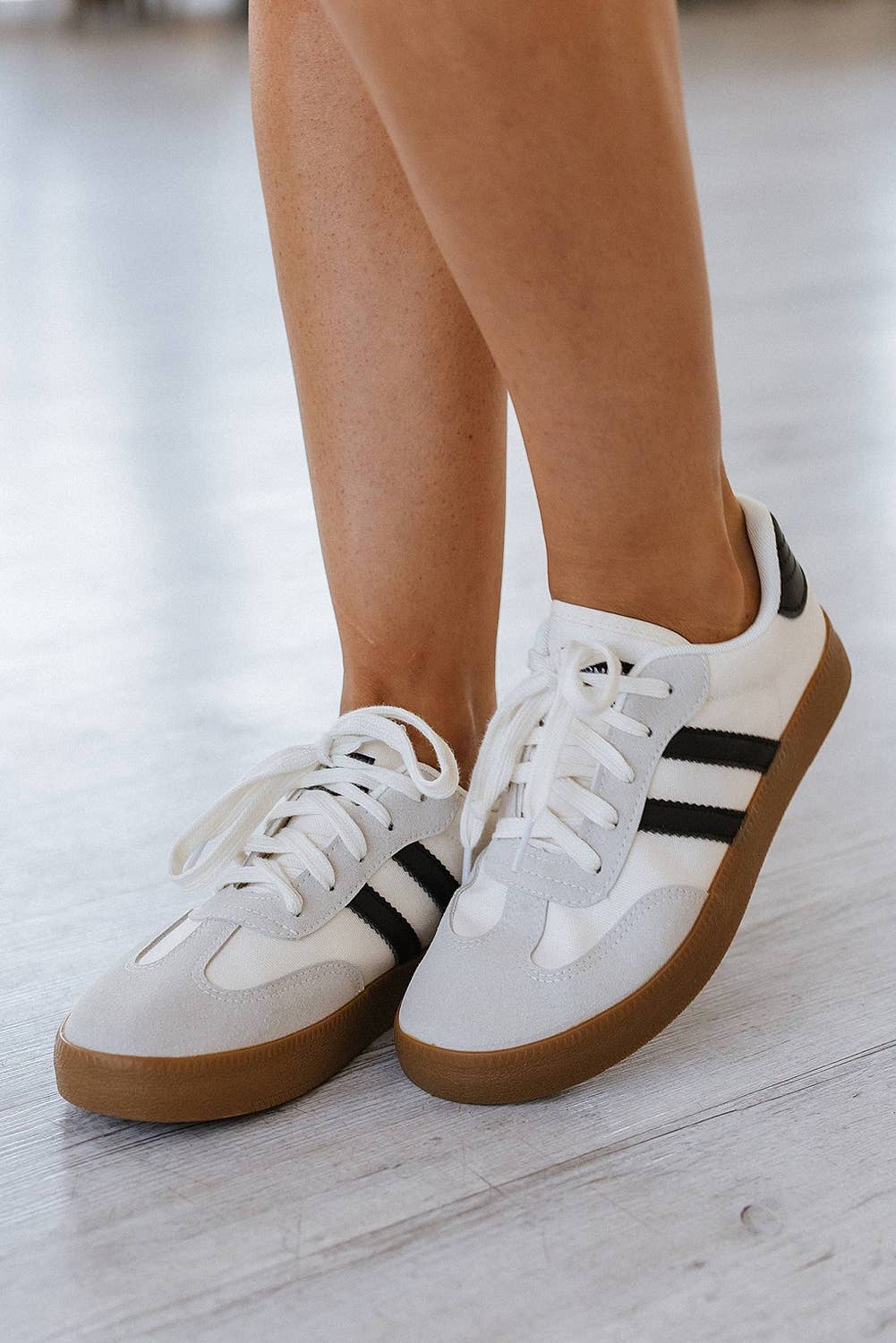 Aapparella striped lace-up sneakers in white with black stripes and gum sole for casual wear