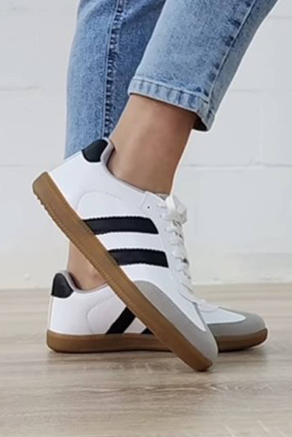 Aapparella striped lace-up sneakers in white with black stripes and brown sole for casual wear