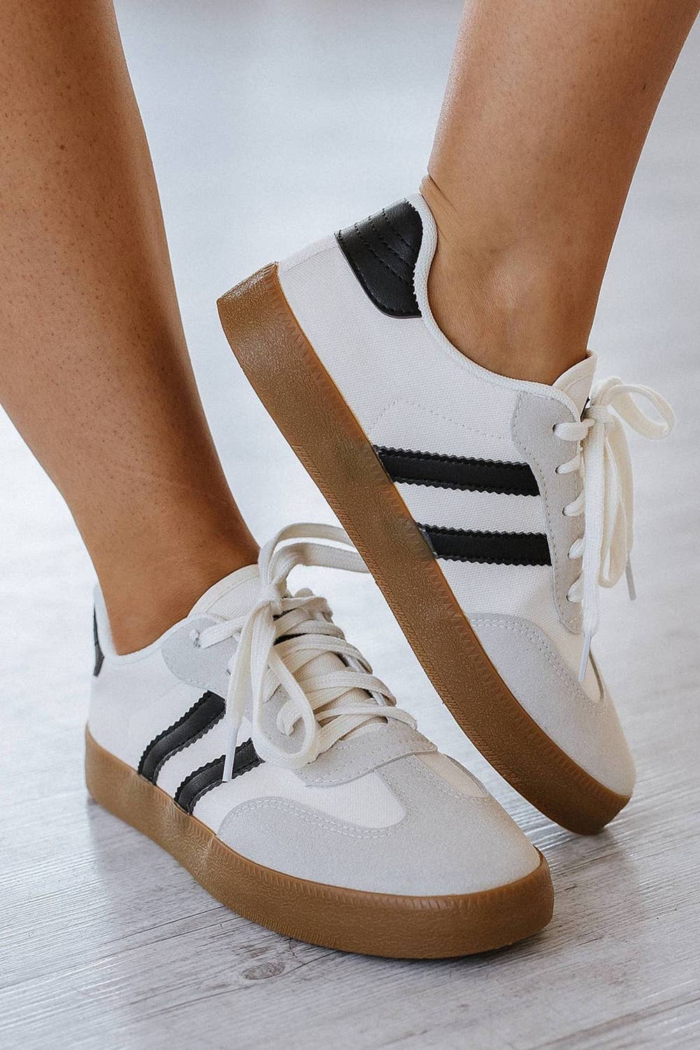 Aapparella striped lace-up sneakers in white and black with a stylish gum sole and casual design