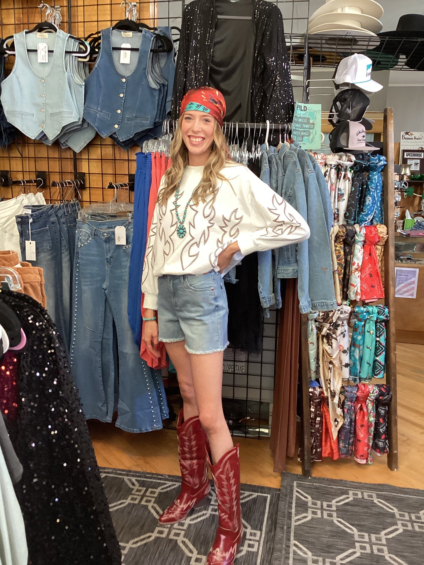 Trendy woman wearing Western Boot Stitch Pullover Sweatshirt with shorts and red cowboy boots